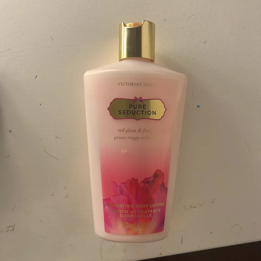 Hydrerande body lotion från Victoria's Secret i doften Pure Seduction med inslag av röd plommon och fresia. Flaskan är rosa med en gyllene kork och har en elegant design. Perfekt för att återfukta huden och lämna en ljuvlig doft.. Perfume.