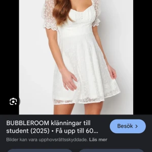 Vit klänning från Bubbleroom - Charmig vit klänning från Bubbleroom med kort längd och puffiga spetsärmar. Den har en söt hjärtformad urringning och ett lätt utsvängt kjolparti. Perfekt för sommarens festligheter!