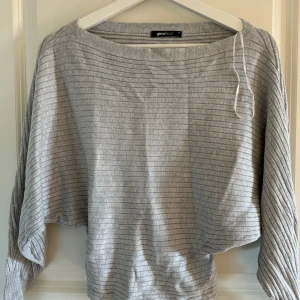 Grå ribbad tröja från Gina Tricot - Säljer en stilren grå ribbad tröja från Gina Tricot. Tröjan har en lös passform med långa ärmar och en rund halsringning. Perfekt för en avslappnad look.