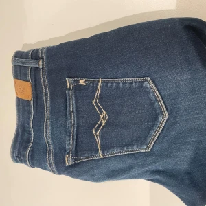 Blå jeans med fransade kanter - Snygga blå jeans med fransade kanter och klassisk femficksdesign. De har en cool, sliten look med ljusare partier och kontrastsömmar. Perfekta för en avslappnad stil.
