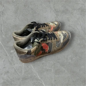 Valentino Garavani Rockrunners - Tja, säljer nu ett par as feta rockrunners från Valentino med ett coolt camouflagemönster i gröna, bruna och svarta toner. Skorna har svarta snören och en robust sula. Perfekta för en avslappnad och stilren look. Tveka inte att höra av er vid funderingar🥂