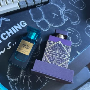 Parfymer Neroli Riviera och Infini Elixir - Två exklusiva parfymer: Neroli Riviera i en elegant blå flaska med guldtext och Infini Elixir i en lila flaska med geometriskt mönster. Perfekta för den som älskar unika dofter. Båda är nästan nya 