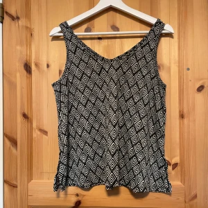 Svartvit mönstrad linnetopp - Säljer en svartvit linnetopp, den är knappt använd, den har dock ingen storlekslapp eller märkeslapp men den passar som S.
