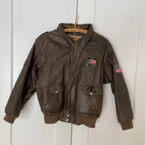 Cool vintage läderjacka  - Den coolaste vintage läderjackan, 100% äkta läder och lite sliten i looken men allt är helt och fungerande. Står ingen storlek men tycker den är oversized på en xs-s och mer normal storlek på en s-m. Obs! Förra ägarens namn står skrivet, se bild. 