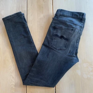 Mörka Nudie Jeans - Tjena! Säljer ett par svart/gråa nudie jeans med en riktigt snygg tvätt. Modellen heter ”Lean Dean” och jeansen är i storlek 29/32. De har en liten defekt vid grenen, men ingenting som syns när de är på. Man kan även då laga dessa gratis på en nudie affär! Hör av er vid närmsta fundering!🙏🙌