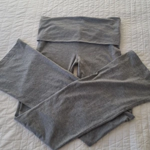 Grå leggings från Gina Tricot - Snygga grå leggings från Gina Tricot med en stjärndetalj på ena benet. De har en bekväm passform, perfekta för en avslappnad stil. Tillverkade i mjukt material som ger en skön känsla hela dagen. Nästan aldrig använda. Möts bara upp