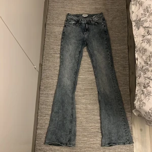 Blå lågmidjade bootcut jeans från Weekday - Snygga lågmidjade blå bootcut jeans från Weekday i en cool tvätt. De har en klassisk femficksdesign och är tillverkade i en bomullsblandning med lite stretch för extra komfort. Perfekta för en avslappnad stil. De ska vara low men de är mer midwaist enligt mig 🤍