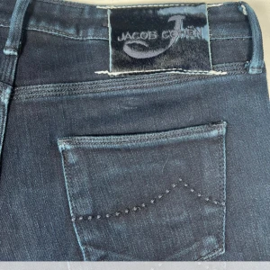 Mörkblå jeans från Jacob Cohen - Snygga mörkblå jeans från Jacob Cohen i en klassisk design. De har en femficksmodell med subtila sömdetaljer och en logotyp på bakfickan. Perfekta för en stilren look.