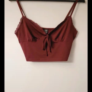 Vinröd croppad linnetopp - Snygg vinröd croppad linnetopp från shein med spetsdetaljer och knyt framtill. Perfekt för en trendig look. med smala axelband.❤️