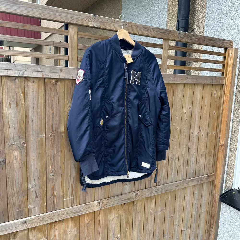 Säljer en snygg mörkblå bomberjacka med coola broderier och detaljer. Jackan har en dragkedja framtill och ribbade muddar vid ärmslut. Den har ett stort 'M' på bröstet och broderade märken på ärmen. Perfekt för en avslappnad stil. Från märket Odd Molly i storlek 1 som enligt deras storleksguide motsvarar en storlek S. Mycket fint skick, jag hittar inga synliga anmärkningar eller defekter. . Takit.