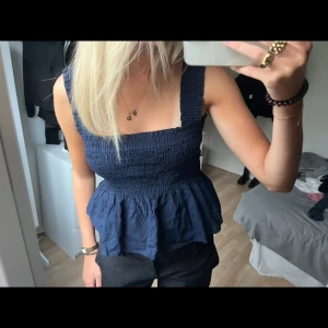 Blå topp - Säljer mitt volang linne från uniqlo, köpt i somras men aldrig använt med lapp kvar💓 L men passar xs-m eftersom materialet är stretchigt,  använd gärna köp nu