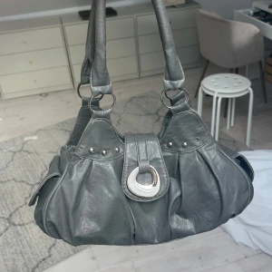 Mörkgrå väska - Väldigt rymlig väska som jag inte använder längre, köpt på plick. Väl använd men i fint skick