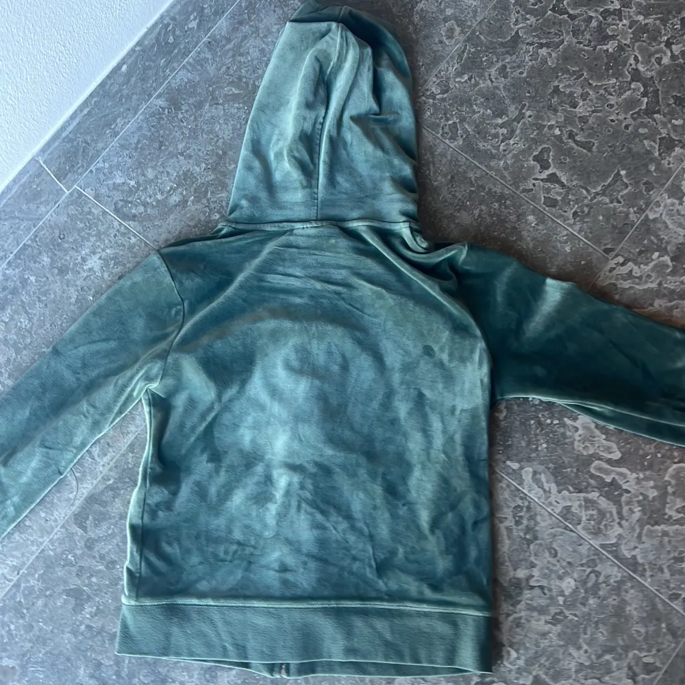 Säljer en supermjuk och snygg grön hoodie från Juicy Couture. Den har en dragkedja framtill och en praktisk huva. Perfekt för en avslappnad stil eller mysiga dagar hemma. Den är i bra skick och redo för en ny ägare!. Jackor.