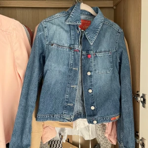 Jeansjacka från Vique - Säljer en snygg jeansjacka från Vique i storlek S. Den har en klassisk blå denimfärg med knappar framtill och en bröstficka. Perfekt för vår och höst!