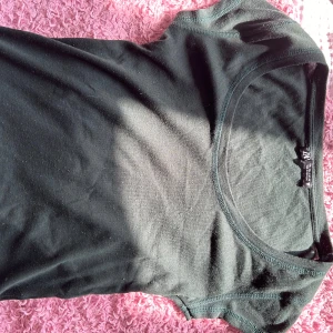 Svart t-shirt från H&M - Säljer en enkel och stilren mörk grön t-shirt från Zara. Den är i ett mjukt bomullsmaterial och har en rund halsringning. Perfekt för vardagsbruk eller som basplagg i garderoben.( färgen på tröjan syns inte så bra) ❤️