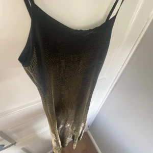 Svart och guld glittrig klänning från Fabuline - Säljer en supersnygg/unik svart, guld & glittrig klänning från Fabuline😍klänningen skiftar ifrån att se helt svart ut till att se ”guldglittrande ut” beroende från vilket ljus och håll man kollar från!🥰