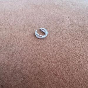 Ear Cuff Thomas Sabo - Ear cuff i silver från Thomas Sabo i en omlott design. Endast använd ett fåtal gånger, mycket bra skick. Sista bilden illustrerar märkningen av Thomas Sabo i smycket.