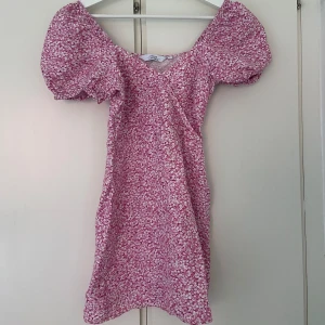 Miniklänning & other stories - Rosa blommig kort klänning med puffärmar från Other stories. Linne och viskos är materialet. Knapp i urringningen och gömd dragkedja i sidan. Storlek XS