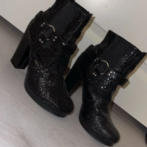 Svart glittriga klackar - Snygga glittriga svarta klackar. Jag säljer dessa för att de inte används. De ramlar av lite glitter och de är en reva på ena klacken