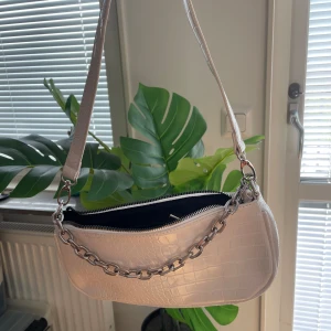 Vit handväska  - Liten vit handväska med silverkedja, riktigt cool och trendig. Knappt använd, bra kvalite. 