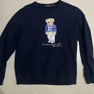 Säljer en snygg mörkblå tröja från Ralph Lauren med polo bear på framsidan. Tröjan är långärmad och gjord i mjuk bomull. Den har en liten passform och är i bra skick. Köptes in för cirka 1 år sen i Spanien, kan tänkas byta mot rph zip. Kom med bud🤩👍