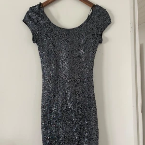 Kortärmad nyårsklänning  - En jättefin klänning med paljetter, perfekt till nyår. Den är lite öppen i ryggen och har en så fin passform. Säljer för att jag har en annan klänning till nyår, jättefint skick! 💕