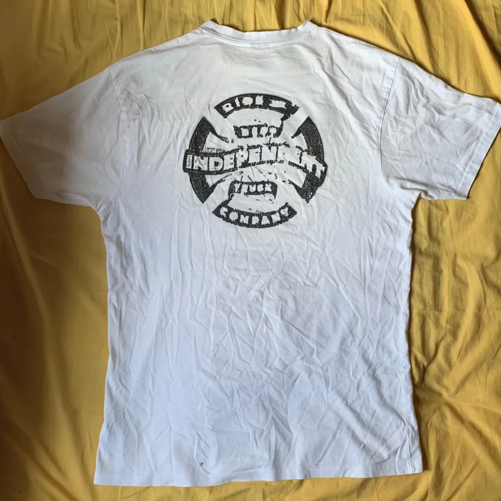 Säljer  en vit t-shirt från Independent Truck Company  L. Den har en cool 'INDEPENDENT' text på framsidan och ett stort tryck på baksidan. Trycken är slitna och det finns flera fläckar, men fortfarande en väldigt cool tröja.. T-shirts.