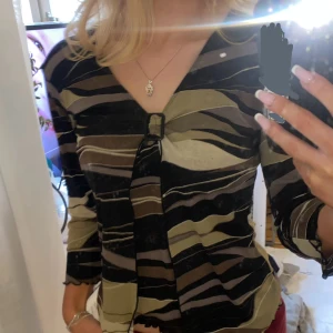 Unik Topp🙌🏼🌟 - Unik topp som faller fantastiskt på kroppen💫🌔 perfekt till fest eller vardag✨ superfina färger och detaljer, som volangerna och spännet i mitten🙌🏼 vintage Lite sliten längst ner men det syns inte så mycket🫶🏼