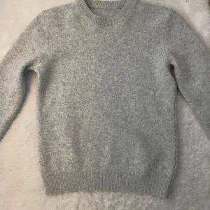  stickad grå tröja - En fin grå stickad tröja, använd 1 gång och säljer då den inte kommer till användning 