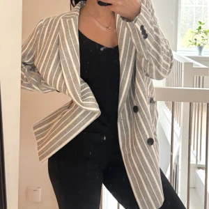 Grå vit Jacka / blazer  - Grå och vit randig blazer / jacka med svarta knappar. Perfekt oversized storlek  och tjockt lyxigt material! Köpt från h&m, använd en gång!  
