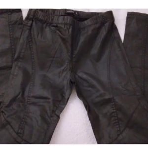 Svarta vaxade treggings, Strlk: 34. Lindex. Felfria. - Svarta vaxade treggings, Strlk: 36/XS-SMALL. Från Lindex.  Har resår i midjan. Snygga sömmar på benen, vid knäna bla. Ingen gylf. Felfria.