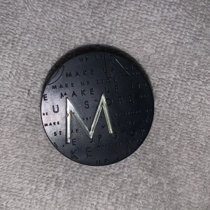 Grön ögonskugga från Make Up Store - Snygg grön ögonskugga i nyansen 'Paradise' från Make Up Store. Kommer i en stilren svart förpackning med ett stort M på locket. Perfekt för att skapa en unik look med en pop av färg.