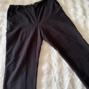Svarta kostymbyxor från H&M - Snygga svarta byxor från H&M med elastisk midja 💕Perfekta för en stilren look. Raka i benen💕