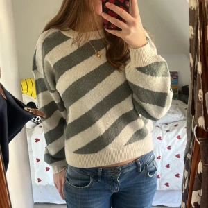 Randig tröja från Vero Moda - Säljer en mysig randig tröja från Vero Moda i grön/grå och beige/vit💕. Tröjan har långa ärmar och en bekväm passform, perfekt för kyligare dagar. Den är tillverkad i ett mjukt material som känns skönt mot huden. Den är endast använd 1 gång så den är helt i nyskick. Köpte för 500kr men säljer då jag inte fått nån användning för den. 💕