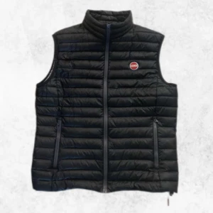 Svart dunväst från Colmar - Säljer en snygg svart dunväst från Colmar med dragkedja. Västen är lagad på ett litet ställe som ni ser på tredje bilden vilket knappt syns men förutom det är den i väldigt fint skick. Det är storlek 52 vilket motsvarar en M. Vid fler bilder eller nån fråga är det bara att höra av sig.