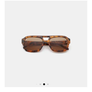 Solglasögon med leopardmönster - Coolq solglasögon med leopardmönstrad båge och bruna linser. De har en modern design med en unik brygga och fyrkantig form. 