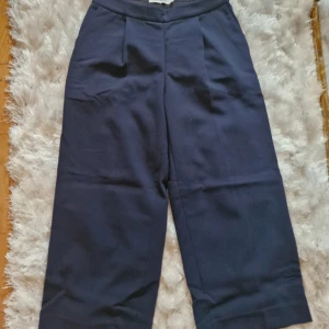 Mörkblåa kortare kostymbyxor från Carin Wester  - Snygga mörkblåa byxor från Carin Wester, strl 36. Vadlånga! Perfekta för en stilren look. 