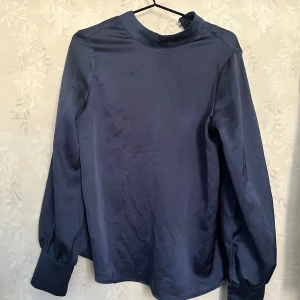 Marinblå siden blus - Säljer nu denna marin blå siden liknande blusen ifrån SHEIN. Köpte för något år sedan och är andvänd cirka 3 ggr. Den är i storlek xs och skulle även säga att den är sann i storleken❤️ skriv ifall ni har frågor eller vill ha mer bilder🥰