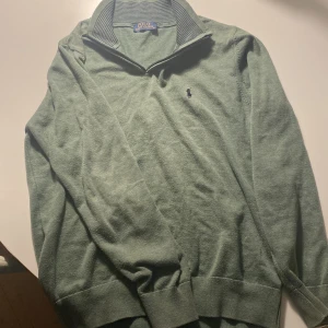 Grön tröja från Ralph Lauren - Säljer en stilren grön zip hoodie från Ralph Lauren. Den har ingen drag kedja men det ser inte alls konstigt ut. Den är S som även passar M. Jätte skönt material