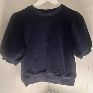 Mörkblå tröja från Gina Tricot - Säljer en stilren mörkblå tröja från Gina Tricot. Tröjan har korta puffärmar och en rund halsringning. Perfekt för en avslappnad look. Passar bra till både jeans och kjol. SKRIV OM NI HAR FRÅGOR!!😊