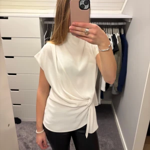 Vit blus med knyt framtill - Elegant vit blus från zara med knyt i sidan/framtill och korta ärmar. Så snyggt för fester eller en skoldag!! Passar med allt och är så stilren🩵🤍