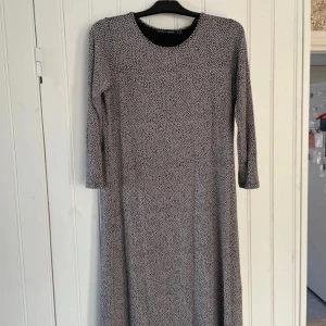 Mönstrad klänning från Gudrun Sjödén - Säljer en stilren klänning från Gudrun Sjödén i storlek M. Klänningen har ett diskret mönster i svart och vitt och är långärmad. Perfekt för en avslappnad och bekväm stil.