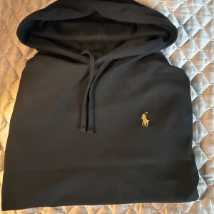Svart hoodie  Ralph Lauren - Säljer nu denna svarta Ralph lauren hoodien i storlek S, tunnt material som gör denna hoodien perfekt för sommaren och våren. Skick 8/10