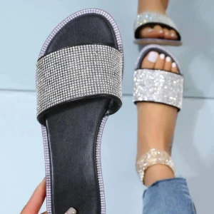 Glittriga sandaler - Snygga glittriga nya sandaler. De har en bred rem täckt av glittrande stenar som ger en lyxig känsla. Sandalerna är svarta med silverdetaljer och passar perfekt till både jeans och klänning. Perfekta för att lysa upp vilken outfit som helst!