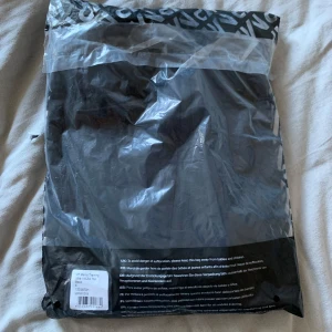 Svart långärmad tröja med dragkedja - Snygg och stilren svart långärmad tröja med dragkedja i halsen. Perfekt för både träning och vardag. Tröjan har en tight passform som framhäver figuren och är tillverkad i ett bekvämt material. Helt ny i orginalförpackning. Storlek s