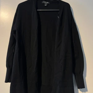 Svart kofta från Amisu - Säljer en stilren svart kofta från Amisu i storlek S. Den är perfekt för höst och vinter med sitt mjuka och bekväma material. Koftan har långa ärmar och en öppen design utan knappar, vilket gör den lätt att matcha med olika outfits. Perfekt för både vardag och fest! 🖤