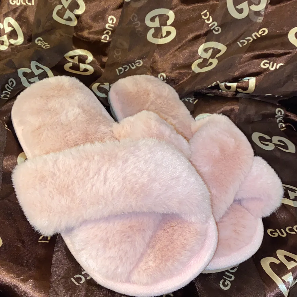 Supermysiga rosa tofflor fluffigt material. Perfekta för att hålla fötterna varma och bekväma hemma. De har en mjuk sula och en stilren design som passar perfekt för en avslappnad dag inomhus. Aldrig använda ny skick 🩷. Kengät.