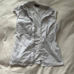 Office siren mini skjorta - Liten skjorta som är croppad i armarna, skit snygg och passar så bra med något över! Storlek S, förlåt för att den är skrynklig!