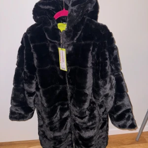 Pälsjacka - Supersnygg svart pälsjacka med luva, två fickor och dragkedja