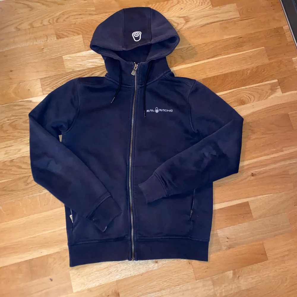 Säljer en mörkblå Sailracing zip hoodie. 10/10 skick. Inga fläckar!  Jag som har m i flesta hoodies skulle vela säga att denna passar även mig nu. Kom dm för intresse och frågor!. Hoodies.